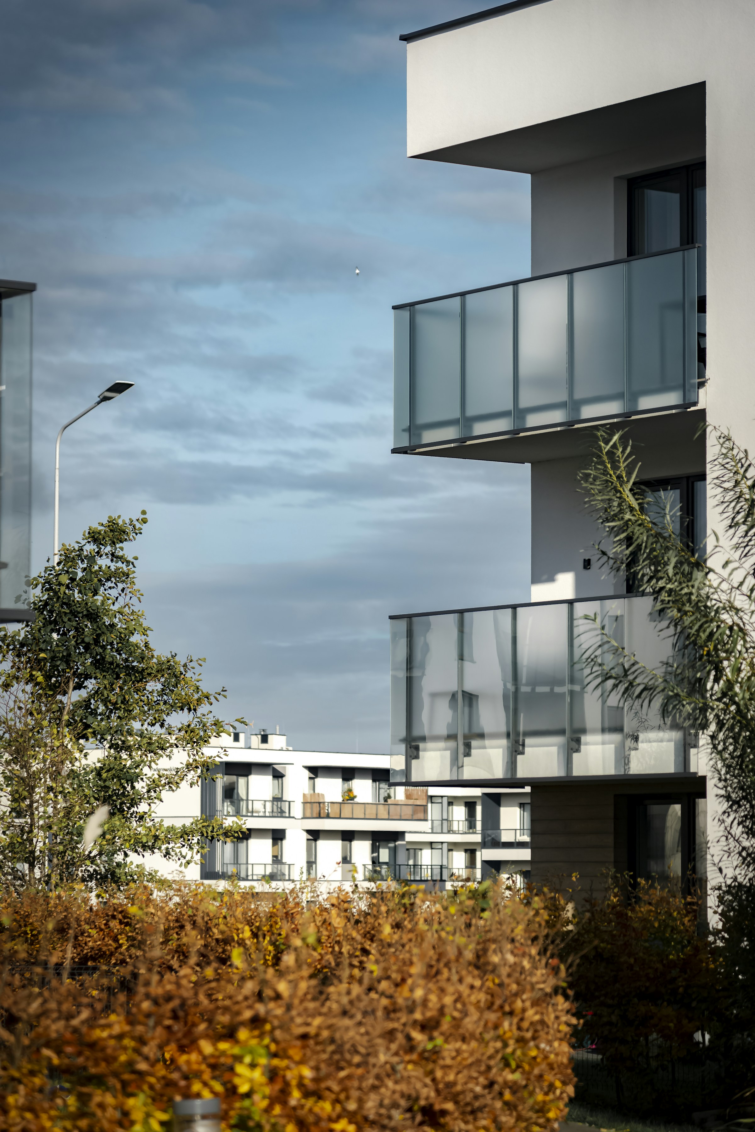 Moderne Wohnanlage mit Glasbalkonen und begrüntem Außenbereich
